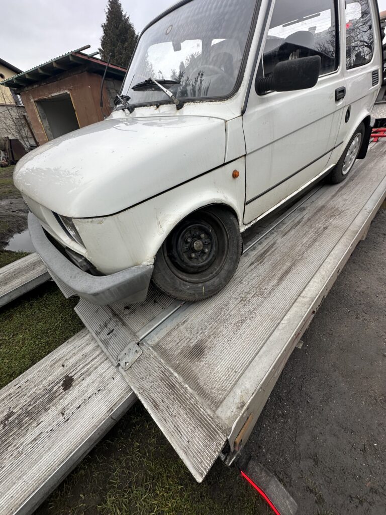 Fiat 126p z zepsutym kołem na lawecie